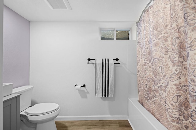 bathroom with wood finished floors, vanity, baseboards, toilet, and visible vents