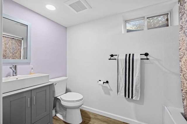 bathroom with toilet, wood finished floors, baseboards, a shower with shower curtain, and visible vents