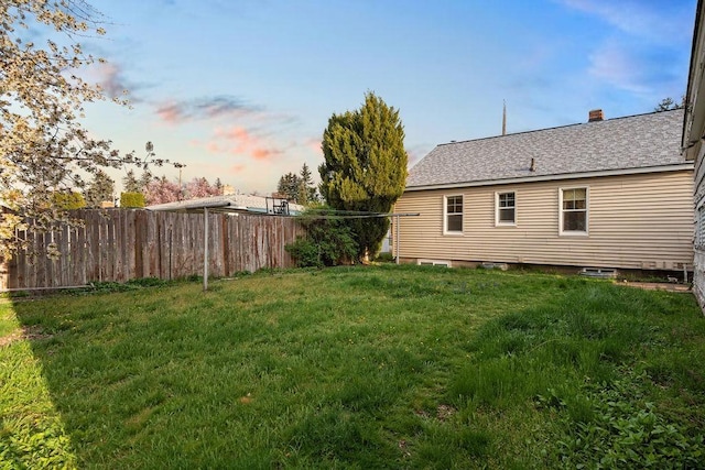 yard at dusk featuring fence