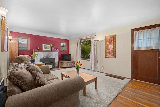 living room featuring baseboards, wood finished floors, and visible vents