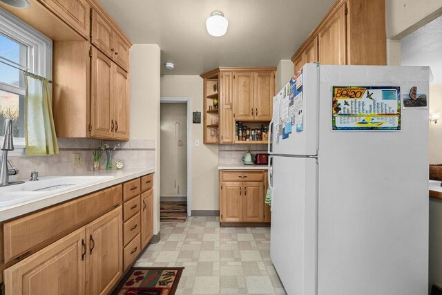 kitchen featuring light floors, open shelves, light countertops, and freestanding refrigerator