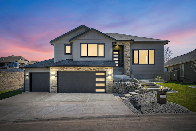 view of front of house featuring a front yard, concrete driveway, stone siding, and board and batten siding