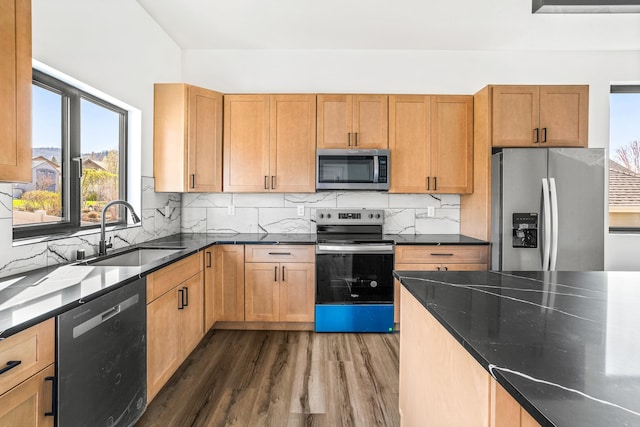 kitchen featuring dark wood finished floors, backsplash, appliances with stainless steel finishes, and a sink