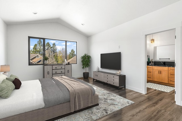 bedroom featuring lofted ceiling, ensuite bathroom, dark wood finished floors, and baseboards