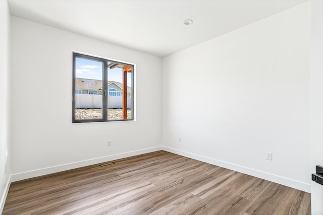 empty room with wood finished floors and baseboards