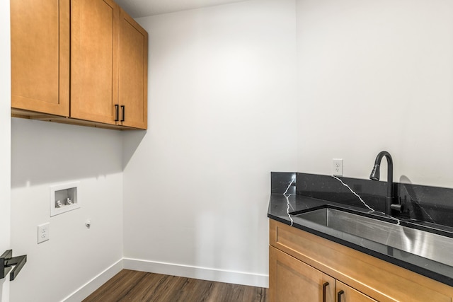 clothes washing area with dark wood-style floors, a sink, cabinet space, hookup for a washing machine, and baseboards