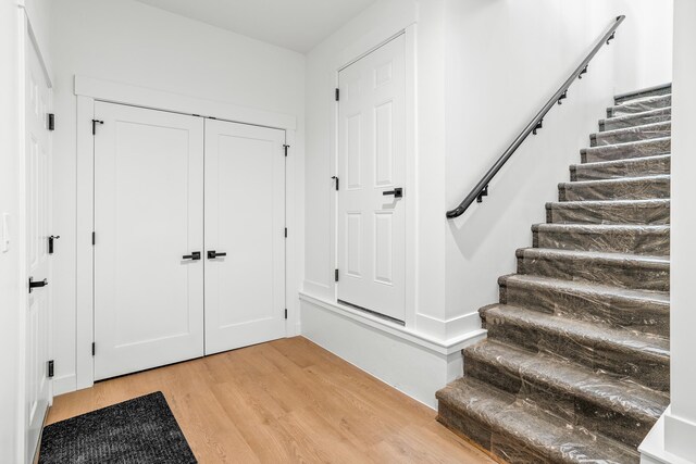 foyer entrance with light wood-type flooring and stairs