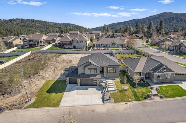 birds eye view of property featuring a mountain view, a forest view, and a residential view
