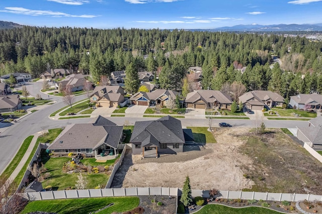 aerial view featuring a wooded view, a mountain view, and a residential view
