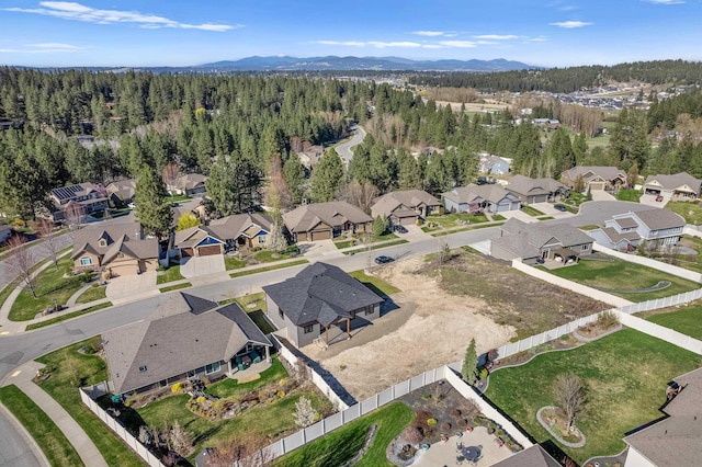 aerial view with a mountain view, a view of trees, and a residential view