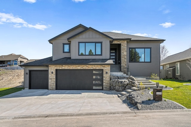 view of front facade with board and batten siding, a garage, stone siding, a front lawn, and concrete driveway
