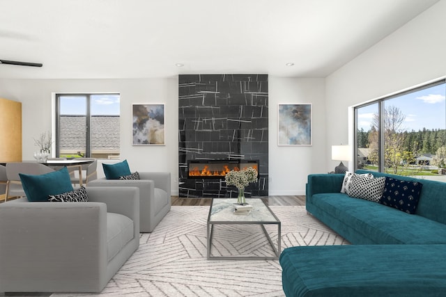 living room featuring a tile fireplace, wood finished floors, recessed lighting, and baseboards