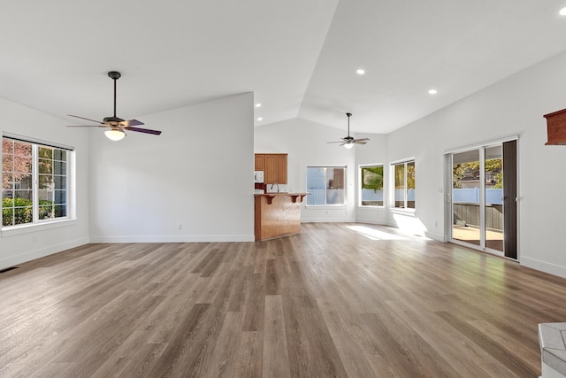 1633 E Northwood Dr, Hayden, ID 83835 - unfurnished living room featuring baseboards, ceiling fan, wood finished floors, and a wealth of natural light