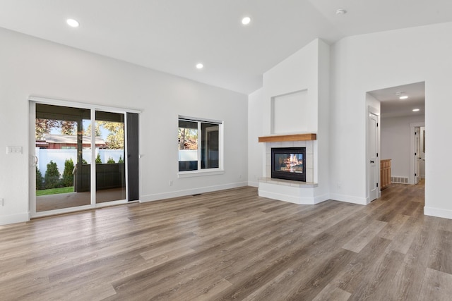1633 E Northwood Dr, Hayden, ID 83835 - unfurnished living room with a tiled fireplace, recessed lighting, visible vents, and light wood-type flooring