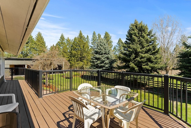 wooden terrace with a yard and outdoor dining space