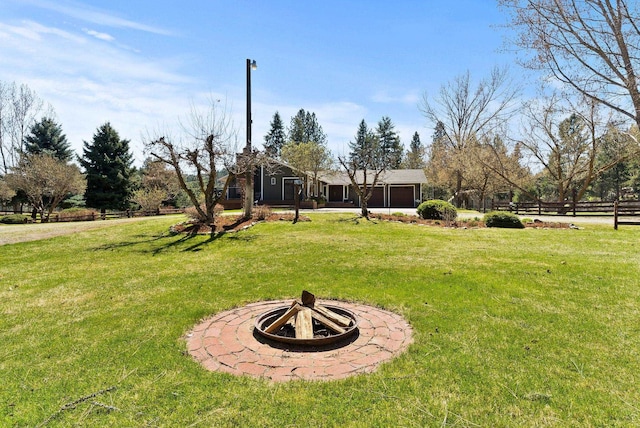 view of yard featuring fence and a fire pit
