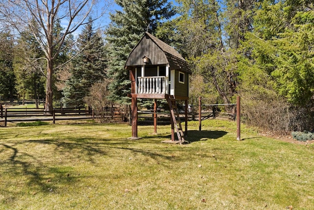 view of jungle gym featuring a lawn and fence