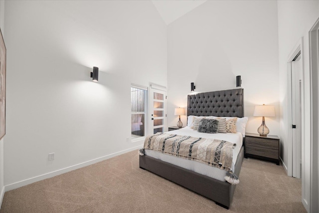 carpeted bedroom with baseboards and high vaulted ceiling