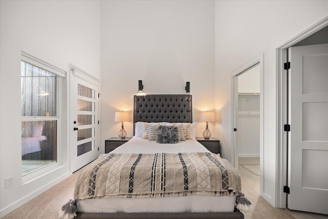 bedroom featuring baseboards, a high ceiling, and carpet