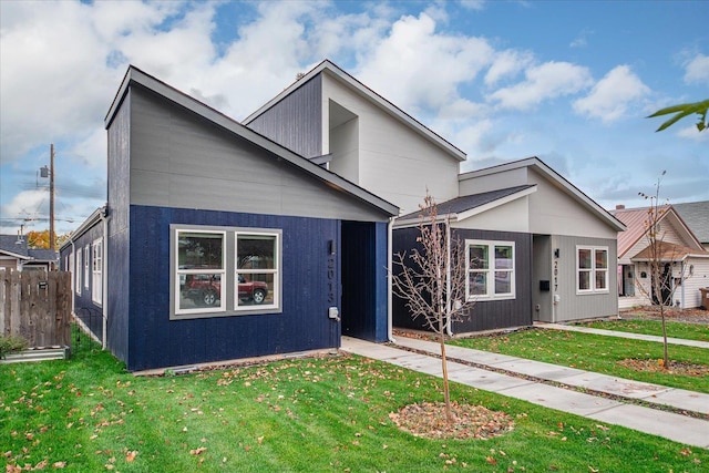 modern home with a front lawn and fence
