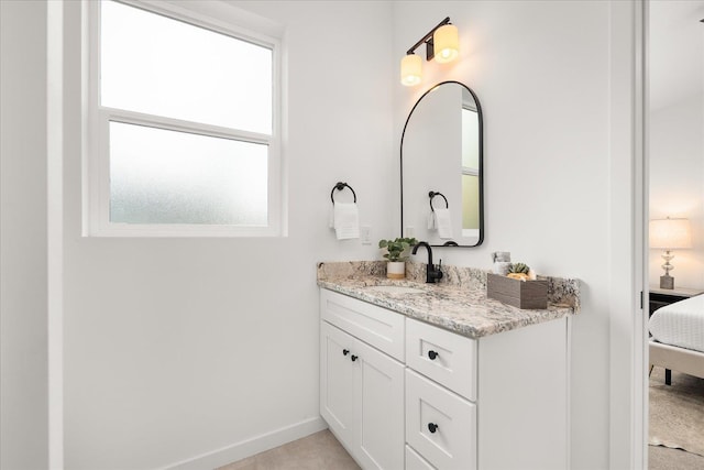 bathroom featuring baseboards, ensuite bath, and vanity