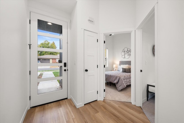 foyer entrance with light wood-style flooring and baseboards