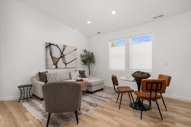 living area featuring baseboards, recessed lighting, and light wood-style floors