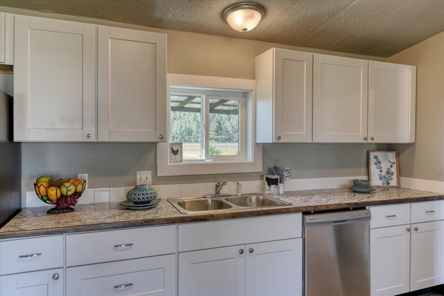 kitchen featuring white cabinets, stainless steel dishwasher, light countertops, and a sink
