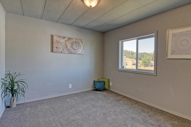 carpeted empty room featuring baseboards
