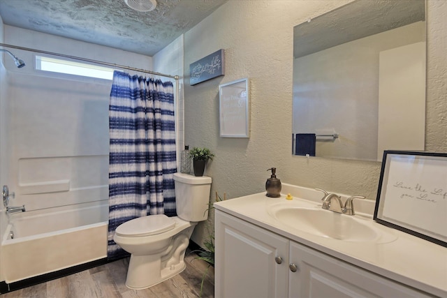 bathroom featuring a textured wall, toilet, vanity, and wood finished floors