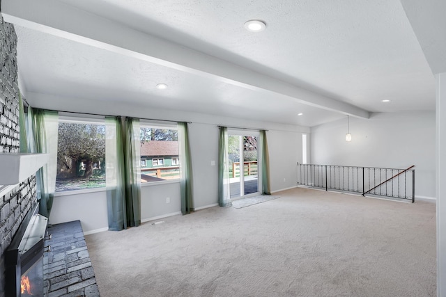 interior space featuring vaulted ceiling with beams, baseboards, recessed lighting, carpet floors, and a lit fireplace