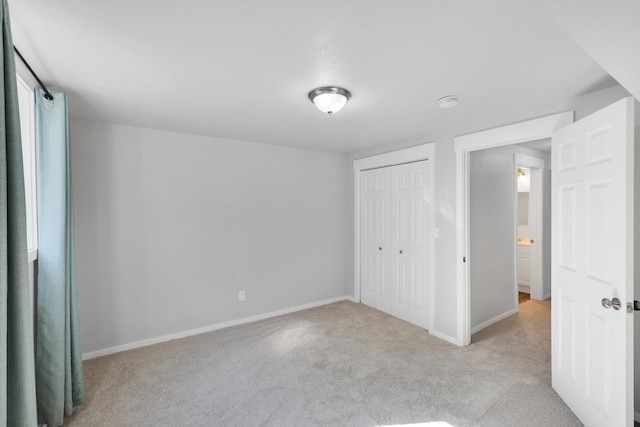 unfurnished bedroom featuring baseboards, carpet floors, and a closet