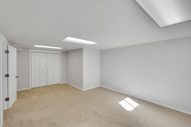 finished below grade area with light colored carpet and baseboards