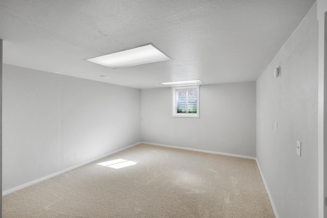 below grade area with baseboards, carpet floors, and a textured ceiling