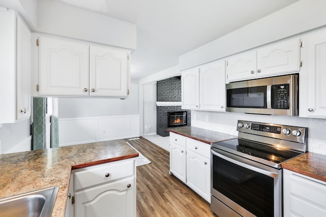 kitchen featuring white cabinetry, stainless steel appliances, and light wood-style floors