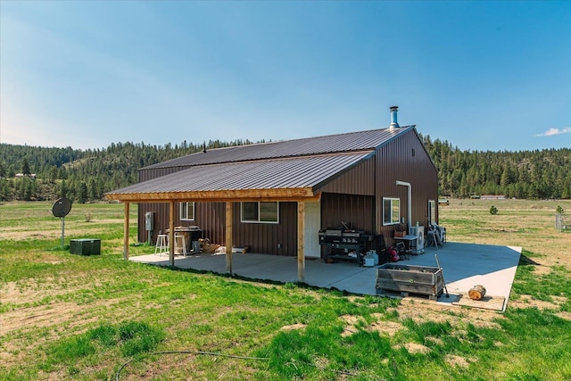 40359 Barbara Ln, Davenport, WA 99122 - rear view of house featuring a patio, a yard, a wooded view, and metal roof