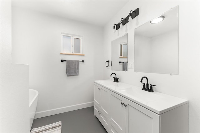 40359 Barbara Ln, Davenport, WA 99122 - full bathroom featuring baseboards, a freestanding tub, a sink, and double vanity