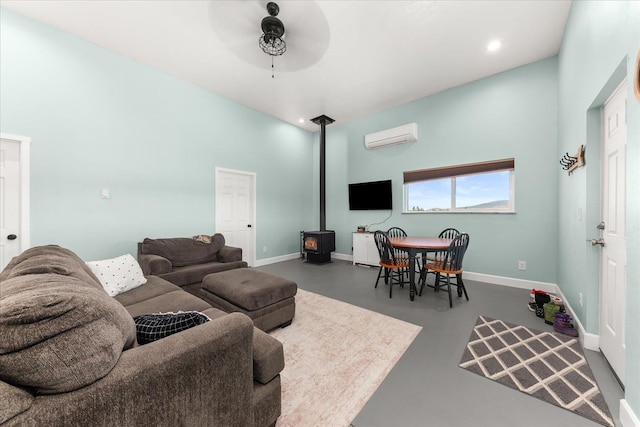 40359 Barbara Ln, Davenport, WA 99122 - living area with baseboards, finished concrete flooring, a ceiling fan, a wall mounted AC, and a wood stove