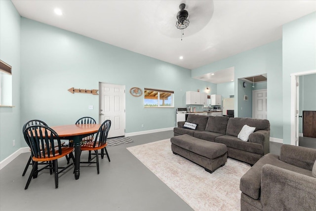 40359 Barbara Ln, Davenport, WA 99122 - living area with baseboards, finished concrete floors, ceiling fan, and high vaulted ceiling