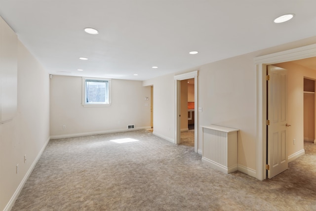 below grade area with light carpet, baseboards, visible vents, and recessed lighting