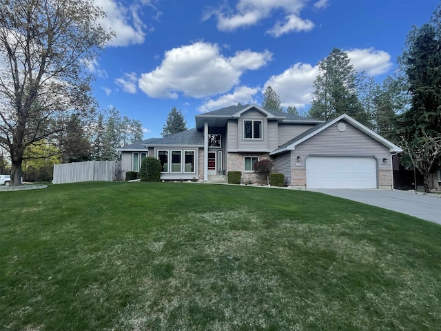 split level home with concrete driveway, fence, a garage, brick siding, and a front yard