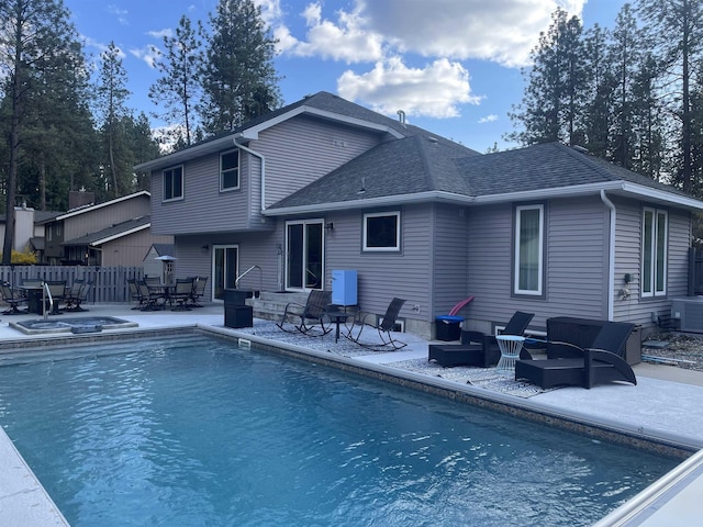 back of property with a fenced in pool, fence, entry steps, a patio, and roof with shingles
