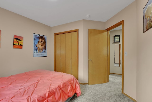 bedroom with a closet, carpet flooring, and baseboards