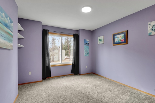 carpeted spare room with visible vents and baseboards