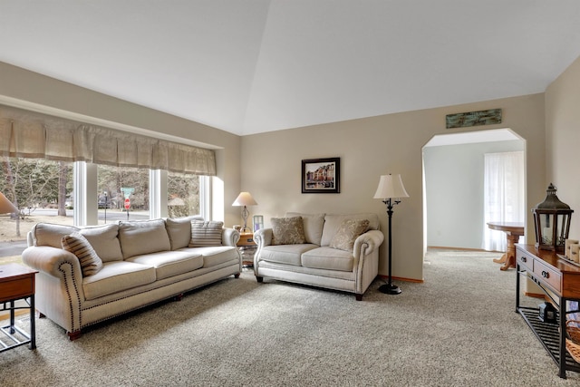 carpeted living area featuring arched walkways, lofted ceiling, and baseboards