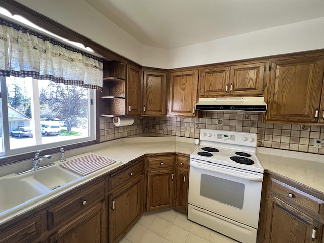 825 N Jefferson St, Colville, WA 99114 - kitchen featuring white range with electric cooktop, a sink, light tile patterned floors, light countertops, and under cabinet range hood