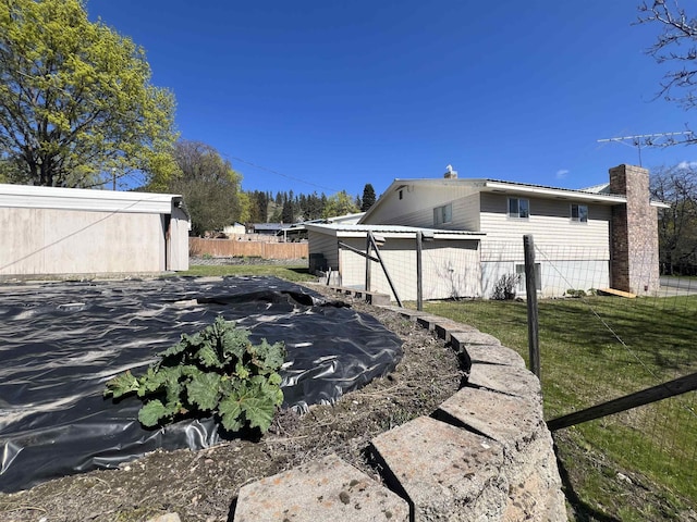 825 N Jefferson St, Colville, WA 99114 - view of home's exterior with an outdoor structure, a chimney, and fence