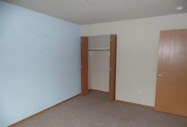 unfurnished bedroom featuring carpet floors, a closet, and baseboards