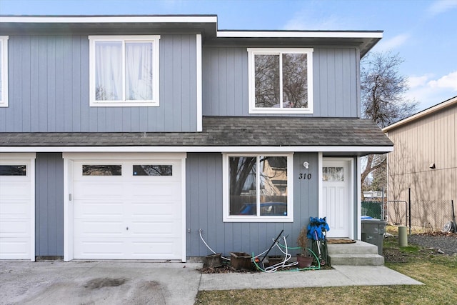 view of front of home with an attached garage and a shingled roof
