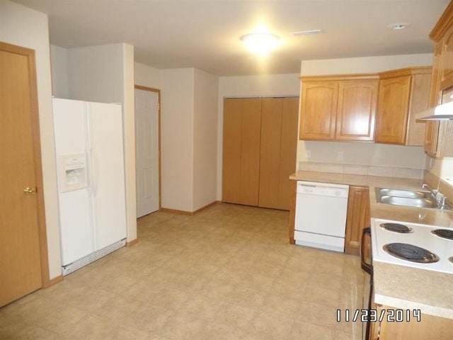 kitchen featuring ventilation hood, a sink, white appliances, light floors, and light countertops